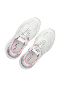 Weiße Sportschuhe aus Mesh- und Leder-Materialien mit pinken Akzenten, einer strukturierten Sohle und kontrastierenden Schnürsenkeln. Branding ist auf den Innensohlen sichtbar.