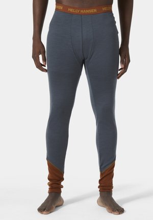Helly Hansen thermoleggings in Dunkelblau mit einem braunen Akzent am Knöchel. Dehnbarem Material, enganliegendem Design, Text auf dem Bund.