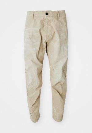 Beige casual pants with button closure and belt loops, slightly wrinkled, laid flat on a white background.