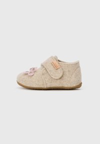 Chaussure en feutre beige avec une sangle Velcro, appliqué floral rose et semelle en caoutchouc pour une bonne adhérence. Conçue pour le confort et la facilité d'enfilage.
