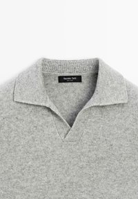 Hellgrauer Strickpullover mit geripptem offenes Kragen und V-Ausschnitt, ausgestattet mit einem schwarzen Massimo Dutti-Etikett im Kragen.