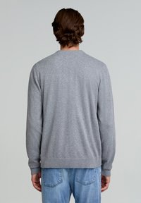 Grå, langærmet sweater lavet af strikket materiale, med en rund halsudskæring og en afslappet pasform. Bagsiden har en ensfarvet tekstur og ribbet kant.