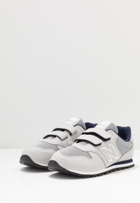 Grå mesh- och syntetiska sneakers med marinblå accenter, som har kardborreband och en texturerad sula. "N"-logotyp på sidan. Säker passform.