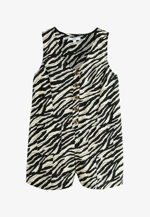 Femeie cu păr lung și castaniu poartă un top fără mâneci cu dungi zebra alb-negru și nasturi din lemn, privind spre dreapta pe fundal de verdeură estompată.