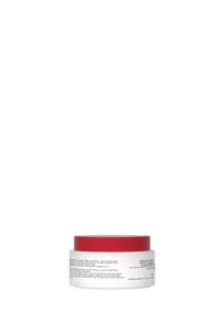 White cylindrical jar with a red lid. The jar contains text in black on the white body, detailing product information.