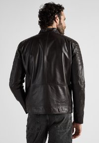 Svart läderjacka med en slät yta, ribbade axelaccenter och synliga sömdetaljer, visad bakifrån.