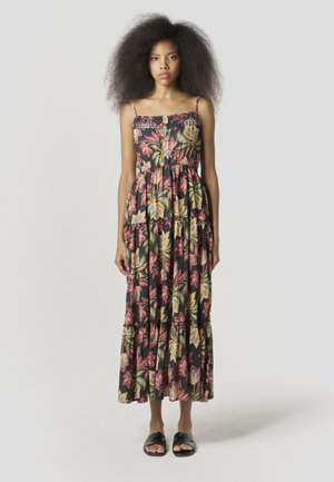 Maxi obleka z naramnicami, črn material z velikimi rdečimi in rumenimi cvetličnimi vzorci, večplastni volančki, kombinirano s flat sandali.