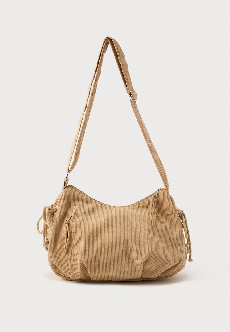 Borsa a spalla in corduroy beige a forma curvata, con tracolla regolabile, dettagli con coulisse e tasche con zip sul davanti.