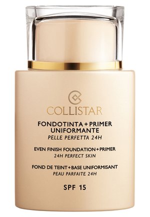 Guld og beige foundation og primer flaske med en klar kappe. Etiket med flersproget tekst og SPF 15 mærkning.