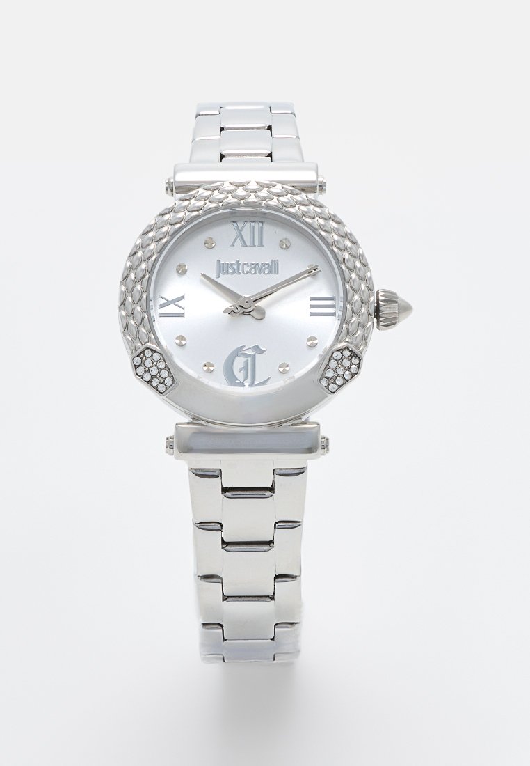 Orologio da polso argentato con cassa rotonda e texture, quadrante bianco, numeri romani e dettagli in cristallo sui lati. Bracciale a maglie in metallo.