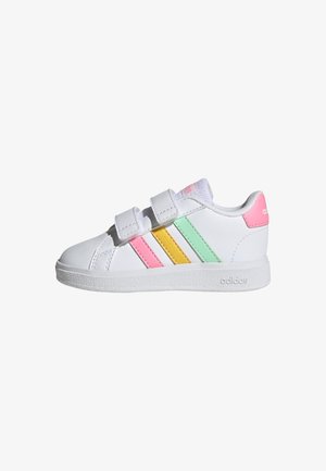 White synthetic sneakers with pink, yellow, and green stripes. Features a Velcro strap design and textured sole for grip.