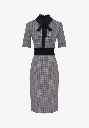 Sukienka midi w czarno-biały wzór, z półdługimi rękawami, szerokim czarnym pasem w talii oraz czarnym kołnierzem z detalem w formie kokardki.