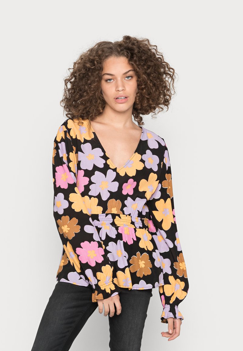 Blusa preta com padrão floral e mangas longas, apresentando padrões de flores roxas, cor-de-rosa e amarelas, com um decote em V profundo e ajustada na cintura.