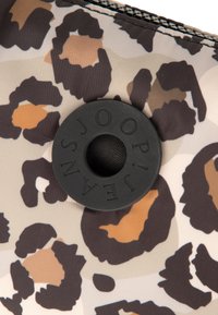 Bolsa de estampado de leopardo fabricada con tela duradera y cierre a presión redondo negro con superficie texturizada y grabado de la marca.