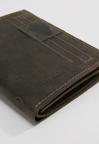 Portafoglio in pelle marrone con cuciture bianche, dotato di uno slot per schede, superficie testurizzata e logo impresso, che mostra un design rettangolare compatto.