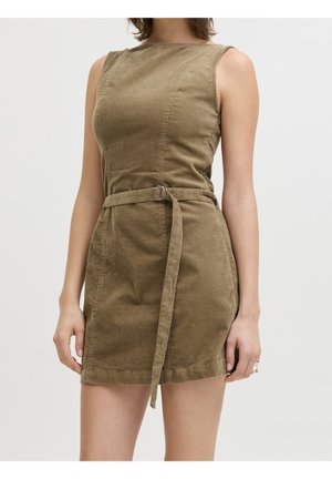 Robe sans manches en velours côtelé vert olive avec un col rond et une taille ceinturée, portée par une personne debout sur un fond uni.