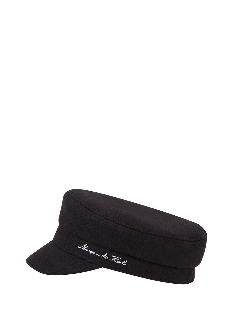 Bonnet en laine noir avec une couronne plate et une visière courte, présentant un logo brodé blanc sur le côté. Texture lisse, forme structurée.