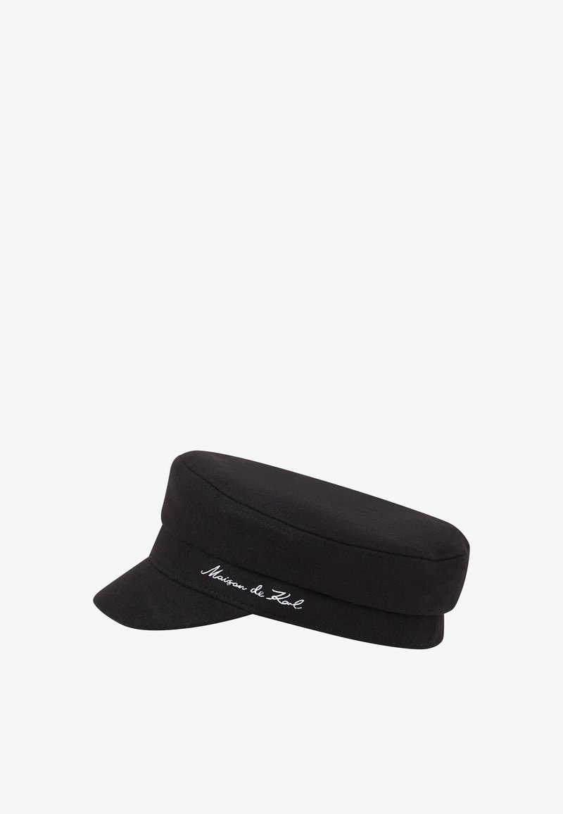 Bonnet en laine noir avec une couronne plate et une visière courte, présentant un logo brodé blanc sur le côté. Texture lisse, forme structurée.