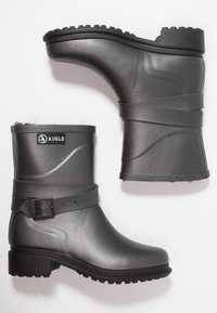 Grijze rubberen enkellaarsjes met een gladde afwerking, voorzien van een gespsluiting en een gestructureerde zool, ontworpen voor duurzaamheid en natte omstandigheden.