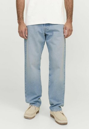 Lichtblauwe denimjeans met een rechte snit, met een vervaagde afwerking en een vijf-pocketontwerp, gedragen met beige instapschoenen.