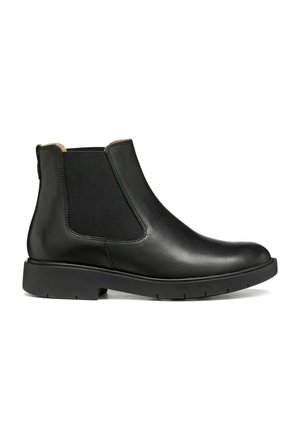 Stivale Chelsea in pelle nera con pannelli laterali elastici e suola bassa e spessa, mostrato dal lato esterno su sfondo bianco.