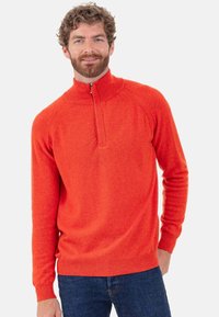 Roter Strickpullover mit Reißverschluss, aus gestricktem Stoff, mit Stehkragen und gerippten Bündchen. Glatte Textur mit figurbetontem Schnitt.