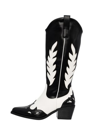 Czarno-białe kowbojskie buty wykonane z materiału skórzanego, z wydłużonym noskiem, dekoracyjnymi wycięciami w kształcie liści po bokach oraz blokowym obcasem.