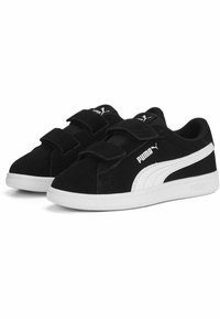 Baskets en suède noir avec des accents blancs, dotées d'un col rembourré, de deux bandes Velcro et d'une semelle en caoutchouc texturé.