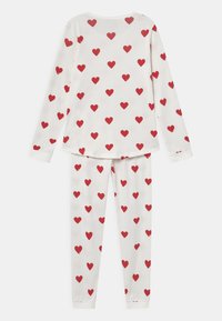 Langermet pyjamasett med en kremfarge bakgrunn og spredte røde hjerte mønstre. Myk stoff, elastisk midjebånd, tettsittende mansjetter på både toppen og buksene.