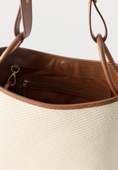 Μπεζ πλεκτή τσάντα ώμου με καφέ δερμάτινες λεπτομέρειες, ρυθμιζόμενο λουρί και εσωτερική τσέπη με φερμουάρ και χρυσό κούμπωμα, κατασκευασμένη στην Ιταλία.