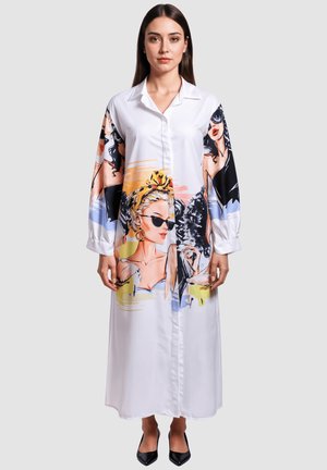 Vestido camisero largo blanco con coloridas ilustraciones impresas de mujeres. Presenta un cuello, cierre de botones en el frente y mangas largas. Textura de tela suave.