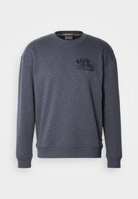 Tamno sivi dukserica od teksturiranog materijala, s okruglim izrezom, rebrastim manžetama i donjim rubom, s crnim PRINTANIM LOGOM na prsima.