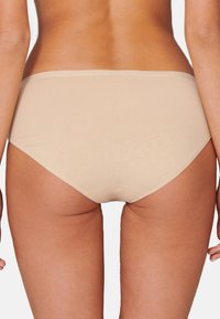 Beige puuvillasegusega aluspüksid, millel on sile ja saumatult disain. Omab madalat lõiget ja pehmet tekstuuri mugavuseks. Ilma nähtavate logode või mustriteta.