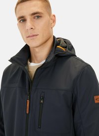 Marineblauer wasserdichter Jacke mit hohem Kragen und angeschnittener Kapuze. Verfügt über Reißverschlüsse, eine Brusttasche und ein kontrastierendes orangenes Futter.