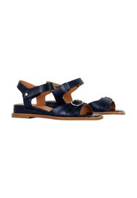 Sandali in pelle blu navy con design a tagli, cinturini regolabili e dettaglio della fibbia rotonda in argento. Suola piatta con accenti color kaki.