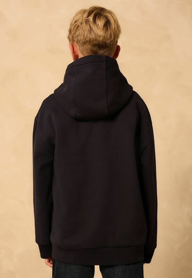 Schwarzer Kapuzenpullover mit entspannter Passform, ausgestattet mit einer gefütterten Kapuze und gerippten Bündchen. Texturiertes Gewebe, keine sichtbaren Marken oder Muster.