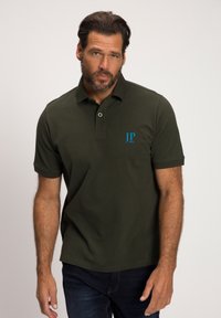 Polo vert foncé en coton, avec un col et des manches courtes. Affiche un logo bleu avec "JP 1880" sur la poitrine gauche.