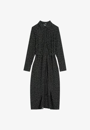 Czarna sukienka midi z długim rękawem w drobne białe groszki, z kołnierzykiem i dopasowanym paskiem z tego samego materiału w talii.