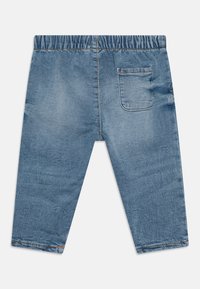 Pantalon en denim bleu clair avec une taille élastique, design cropped et une seule poche arrière. Présente des surpiqûres contrastées pour le détail.