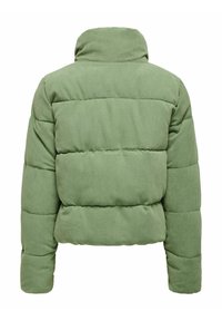 Veste en velours côtelé verte avec un col montant, présentant des sections matelassées, des manches longues et une coupe décontractée. Apparence texturée et douce.