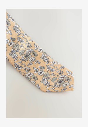 Cravatta gialla floreale con un motivo di fiori blu e bianchi e foglie verdi, realizzata in un tessuto texturizzato, design con estremità affusolata.