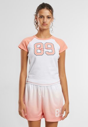 White and light pink athletic set featuring a short-sleeve top with a graphic "89" and matching ombre shorts. Soft fabric, relaxed fit.