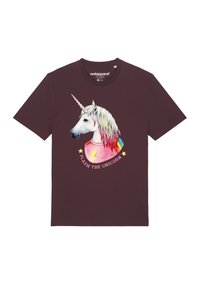 Bordeauxrotes T-Shirt aus Baumwolle mit einem Einhorn- grafiken. Das Einhorn hat einen weißen Kopf und eine mehrfarbige Mähne, trägt ein pinkes Shirt mit gelben Blitzen.