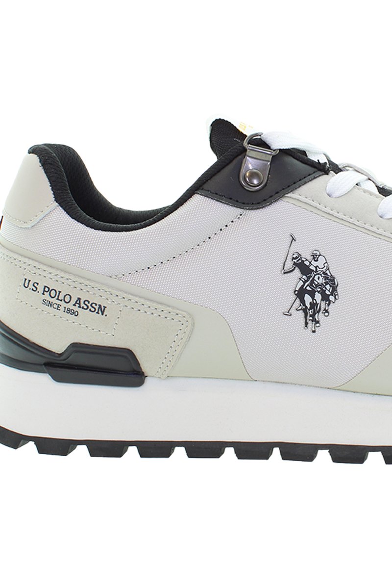 Weiße und schwarze Sneaker der U.S. Polo Assn. mit dem Logo von zwei Polo-Spielern auf dem Seitenbereich.
