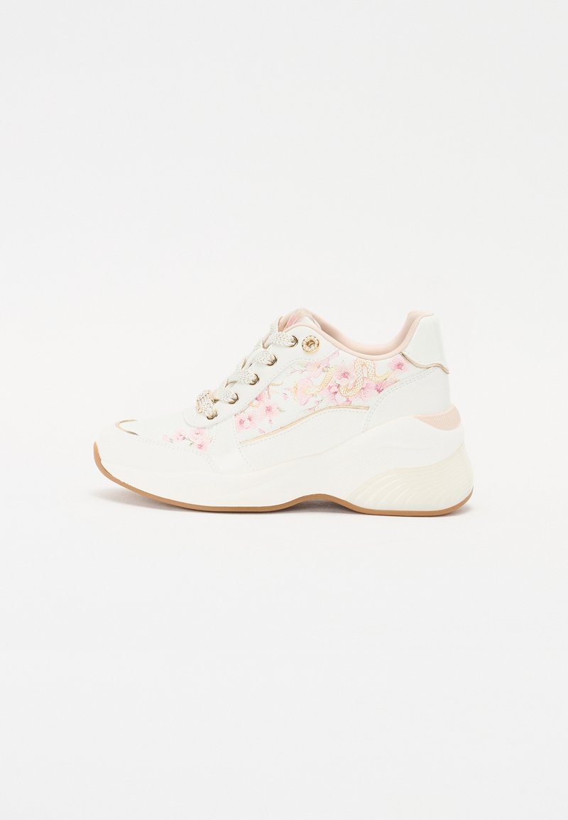 Valkoinen lenkkari, jossa on kukkakuvioinen pinkki kirjailu, pyöreä kärki, kuvioitu pohja ja metalliset reiät nauhoille. Varustettu pehmustetulla kauluksella ja nauhoilla.