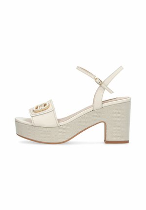 Sandalo con zeppa beige con tacco a blocco, cinturino alla caviglia e dettaglio fibbia dorata sulla fascia anteriore, suola testurizzata, vista laterale su sfondo bianco.