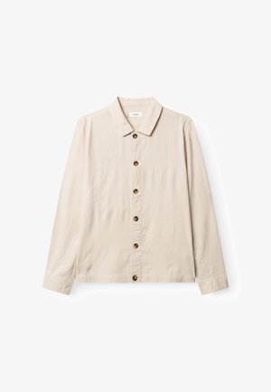 Camisa beige claro de manga larga con botones y cuello, con seis botones oscuros al frente y un sutil bolsillo en el pecho del lado izquierdo.