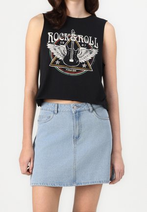 Woman wearing black sleeveless crop top with winged guitar and "Rock & Roll" text, paired with a light blue denim mini skirt.