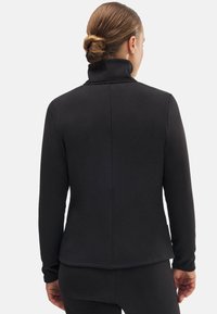 Top negro de manga larga con un cuello alto y una tela suave y texturada. Presenta un diseño ajustado y detalles de costura en la parte posterior.