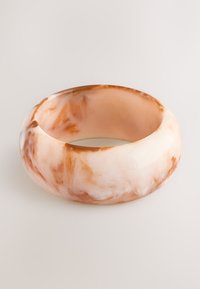 Translucent resin bangle in soft peach and cream hues with marbled patterns, featuring a smooth, rounded shape and glossy surface.
